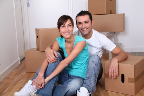 Moving crew carrying furniture through a London residential property
