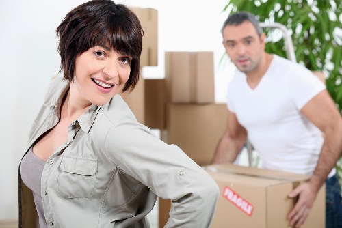 Professional movers carrying furniture through a Brixton property